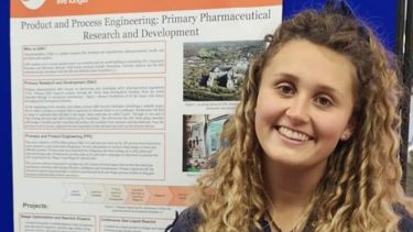 a female student standing in front of a poster presentation